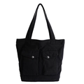 Canvas tote bag in black featuring dual front pockets with silver metal snap buttons - Black
