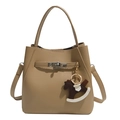 Detailed close-up of camel leather bucket bag with metal lock and rocking horse charm - With Charm / Khaki