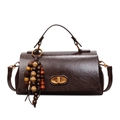 Dark brown leather shoulder bag with gold twist lock and earthy wood bead tassel - With Pendant / Brown