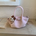 Vue détaillée d'un sac seau plissé rose avec un pendentif ours en peluche sur une pierre - Rose avec pendentif