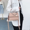 Sac à bandoulière en cuir rose avec chaîne argentée porté par un mannequin - Rose