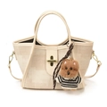 Beige tote bag with gold twist lock and cute plush dog pendant in white background - With Pendant / Off White
