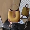 Senfgelbe Beuteltasche mit braunem Besatz und goldenem Drehverschluss in Lederoptik - Gelbbraun