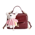 Dettaglio della borsa a tracolla bordeaux lucida con catena dorata e ciondolo a peluche - Con Ciondolo / Rosso