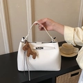 Sac seau en cuir litchi blanc avec fermoir argenté et breloque cheval sur la table - Avec Pendentif / Blanc
