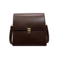 Sac bandoulière rétro marron foncé avec fermoir métallique sur un fond blanc pur - café