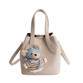 Borsa a secchiello crema minimalista con trama litchi e ciondolo a forma di orsetto - Con Ciondolo / Bianco Sporco