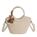 Detailansicht der beigen Eimer-Handtasche mit Ringgriff und stilvollem Pferdeanhänger - Cremefarbene Aprikose