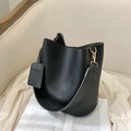 Minimalist black leather bucket bag with wide strap and elegant gold hardware detail - Black