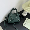 Borsa a mano verde scuro in pelle martellata con borchie e nappine lunghe decorative - verde scuro