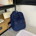 Mini denim backpack in dark blue with lavender straps and orange side label - Dark Blue