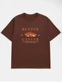 Detail eines dunkelbraunen Baumwoll-T-Shirts mit Butter- und Kaviar-Kunstdruckdesign - S / Kaffeebraun
