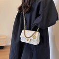 White quilted crossbody bag with gold chain strap worn by model over a dark coat - Off White