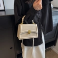 Elegant cream leather crossbody bag with gold interlocking buckle held by model - Off White