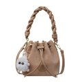 Bolso saco chic marrón claro con asa trenzada y colgante de peluche sobre fondo blanco - Caqui