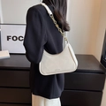 Bolso de media luna blanco con cadena dorada mostrado en el hombro de la modelo - Blanco Roto