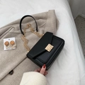 Schwarze Retro Umhängetasche mit goldener Kette auf stilvollem beigem Wollhintergrund - Schwarz