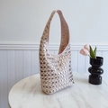 Sac hobo rose orné de rivets argentés sur table en marbre blanc avec fleurs - Rose