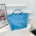 Glänzende hellblaue PVC-Tragetasche mit weißer TOTE BAG Aufschrift und viel Stauraum - Blau