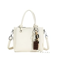 Minimalist beige pebble leather bucket bag with decorative chocolate pendant and strap - Off White
