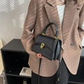 Borsa a mano nera strutturata con dettagli dorati e manico in un contesto lifestyle - Nero