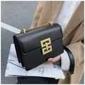 Borsa a tracolla nera con fibbia dorata geometrica e catena indossata da modella - Nero