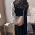 Sac seau marron élégant avec texture litchi et bandoulière sur le modèle - Marron
