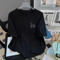 Detail eines schwarzen Baumwoll-T-Shirts mit minimalistischem weißem Hasen-Grafikdruck - Schwarz