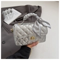 Detail of silver quilted handbag featuring golden twist lock and printed silk scarf handle - Silver