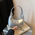 Silver metallic bucket bag with mirror finish and detachable chain strap shown held by hand - Silver (Without Charm)