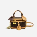 Brown monogram cylinder vanity bag with chain strap and silk wrapped handle in detail - Coffee & Apricot