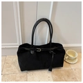 Detail of black matte leather tote bag with glossy straps and gold buckles on stone floor - Black