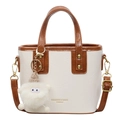 Bolso tipo cubo chic en cuero crema y caramelo con colgante de peluche blanco y oro - Blanco Roto