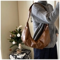 Primer plano del bolso croissant marrón retro con suéter gris y vaqueros oscuros - 43x10x28cm / Marrón