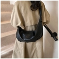Bolso medialuna negro con detalle de nudo en la correa sobre una gabardina color beige - 43x10x28cm / Negro
