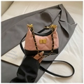 Close-up of pink quilted faux suede shoulder bag with black trim and golden turn-lock - Pink