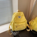 Fashionable bright yellow nylon backpack featuring large capacity and stylish front flap - Yellow
