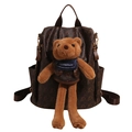 Dunkelbrauner Rucksack aus Kunstleder mit Bärenmuster und großem Plüschbären - Mit Bärenanhänger / Braun / [produktmerkmale]: Dieser Dunkelbraune Rucksack Besteht Hauptsächlich Aus Glänzendem Kunstleder Mit Durchgehendem Bärenmuster. Auf Der Vorderseite Befindet Sich Ein Auffälliger Großer Brauner Plüschbär Mit Dem Aufgestickten Schriftzug „lazybreeze“ Auf Seinem Blauen Lätzchen. Der Rucksack Verfügt Über Ein Großes Hauptfach Und Seitentaschen Sowie Dunkelbraune Schultergurte Aus Stoff Und Goldfarbene Beschläge. [visuelle Präsentation]: Das Bild Zeigt Die Vorderseite Des Produkts Vor Weißem Hintergrund Mit Einem Zentrierten Und Übersichtlichen Layout. Die Bildqualität Ist Hoch Die Materialstruktur Ist Deutlich Erkennbar. Die Ästhetik Ist Ebenfalls Hoch Und Wird Mit 85 Bewertet. Die Gesamtpräsentation Ist Professionell Und Hochwertig. [textinhalt]: Der Englische Text „lazybreeze“ Befindet Sich Ausschließlich Auf Dem Produkt Selbst (plüschbär-accessoire) Gehört Zum Produkttext Und Bedarf Keiner Weiteren Bearbeitung. [logistik-tags]: Keine. [risiko Von Rechtsverletzungen]: Produktrechtsverletzung: Keine; Hintergrundrechtsverletzung: Keine. Dieses Design Gehört Zu Einem Allgemein Niedlichen Stil Und Enthält Keine Bekannten Markenlogos Oder Urheberrechtlich Geschützte Bilder. 【produktparameter】: Rucksack Dunkelbraun Kunstleder Plüschanhänger Bärenmotiv.