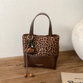 Detail of leopard print stitching and leather bucket bag with decorative floral tassel - Leopard Print With Charm
