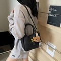 Borsa a secchiello in pelle nera con chiusura dorata, ciondolo orso e tracolla - Con Ciondolo / Nero