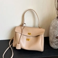 Elegante beige minimalistische Tragetasche aus Leder mit goldenen Schnallen auf Holztisch - Khaki