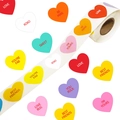 Macro detail of heart-shaped colorful sticker roll with LOVE and XOXO text for gift sealing - Multicolor Heart Style (ZD106)