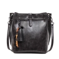 Retro black faux leather bucket bag with tassels and wooden beads on a white background - Black