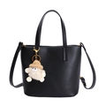 Elegant black lychee textured bucket handbag with gold hardware and plush charm decoration - Black