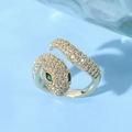 Macro view of crystal-encrusted snake ring with vibrant green gem eyes on blue background - Winding Spirit Snake Green Marquise Eyes Style (JZ0136)