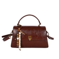 Sac à main rétro en cuir marron avec boucle dorée et pompon perlé sur fond blanc - Cuir PU Marron