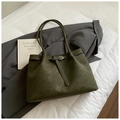Dunkelgrüne matte Shopper-Tasche mit Schnalle und Schultergurten auf grauem Blazer - Grün