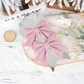 Close-up of pink glitter Christmas bow hair clips on silver card in snowy winter decor - Pink No. 6 Glitter Bow