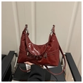 Detalle del bolso hobo de charol burdeos con hebilla plateada y acabado brillante - Rojo