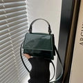 Detalle del mini bolso de mano en piel de charol verde oscuro con acabado brillante - Verde Oscuro